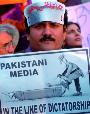 Un periodista sostiene una pancarta contra la censura a los medios